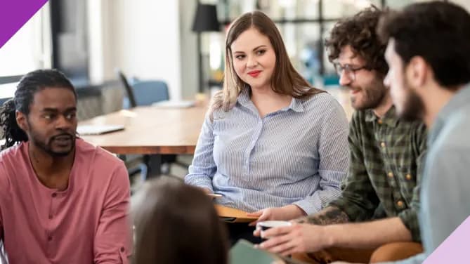 woman sitting with and listening to her colleagues 