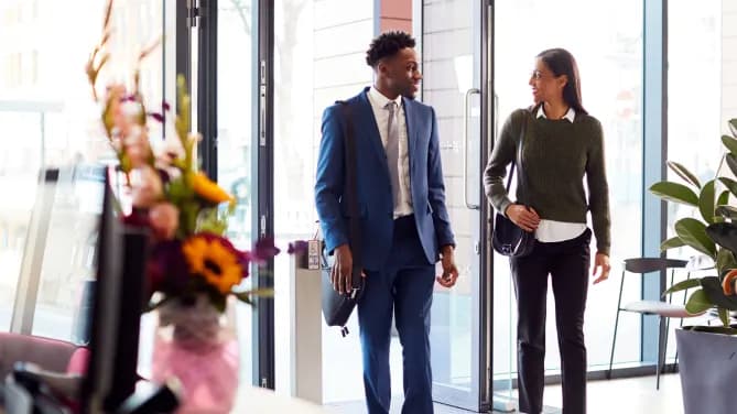 Woman and man walking into work